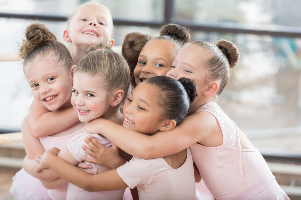 young-ballerinas-form-a-smiling-group-hug-picture-id811106192